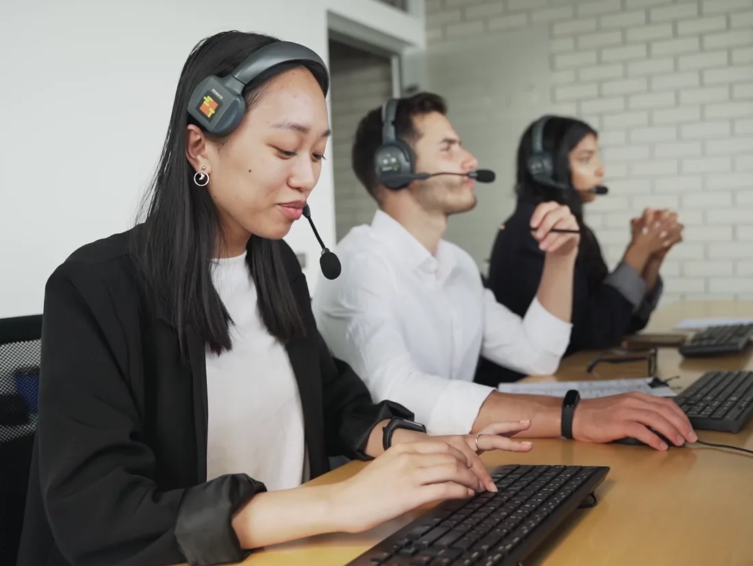 Three agents with headsets working at their desks